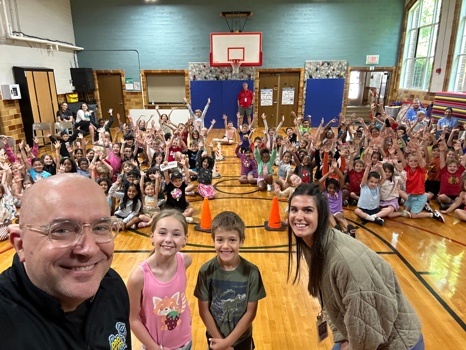 Students and staff smiling together after a Pro-Kids Show assembly at Ellsworth Elementary