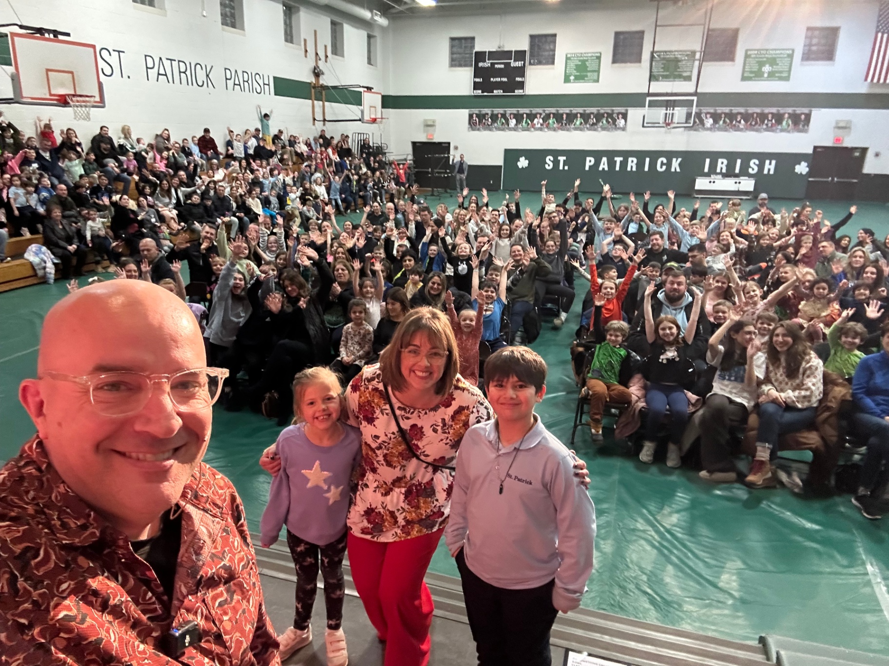 Packed Family Night crowd at a Catholic school with Tim on stage