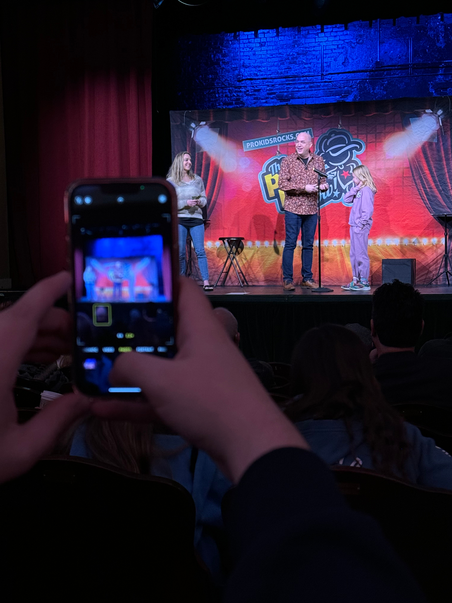 The one moment phones do come out: capturing their own kid on stage.
