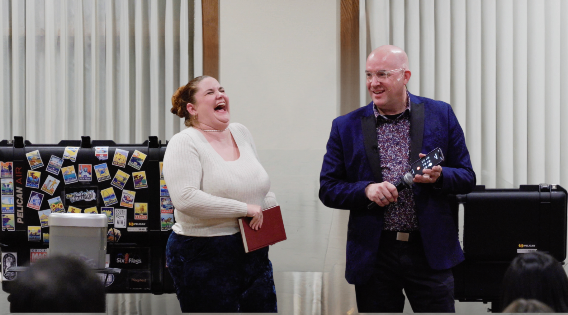 A woman laughing on stage next to Tim during a mentalism bit