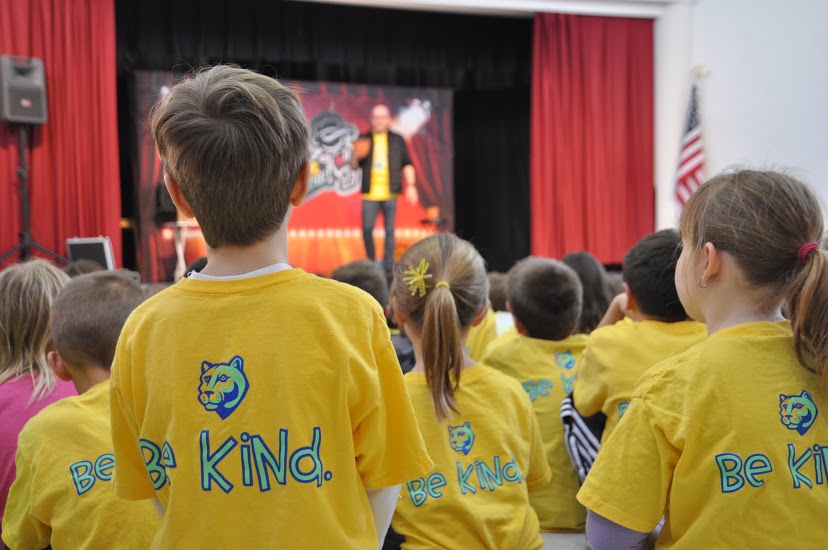 Students laughing and engaged during a kindness-focused school assembly