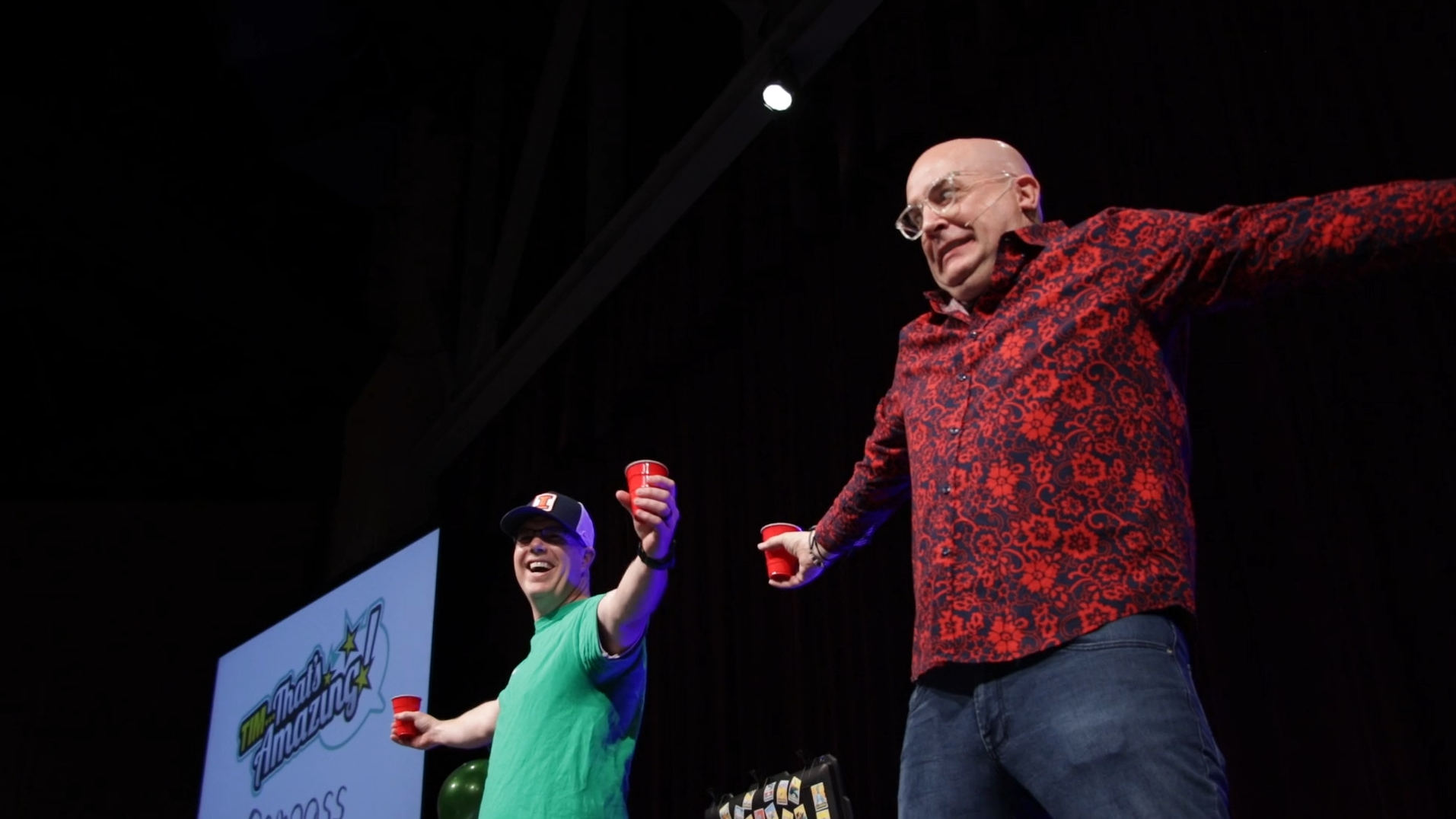 Tim and a volunteer holding red cups during a routine