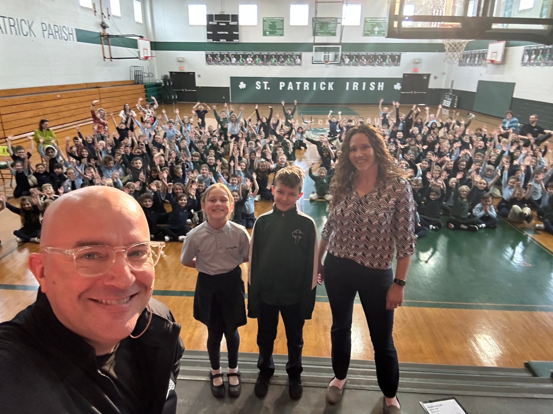 St. Patrick Catholic school assembly with the principal on stage