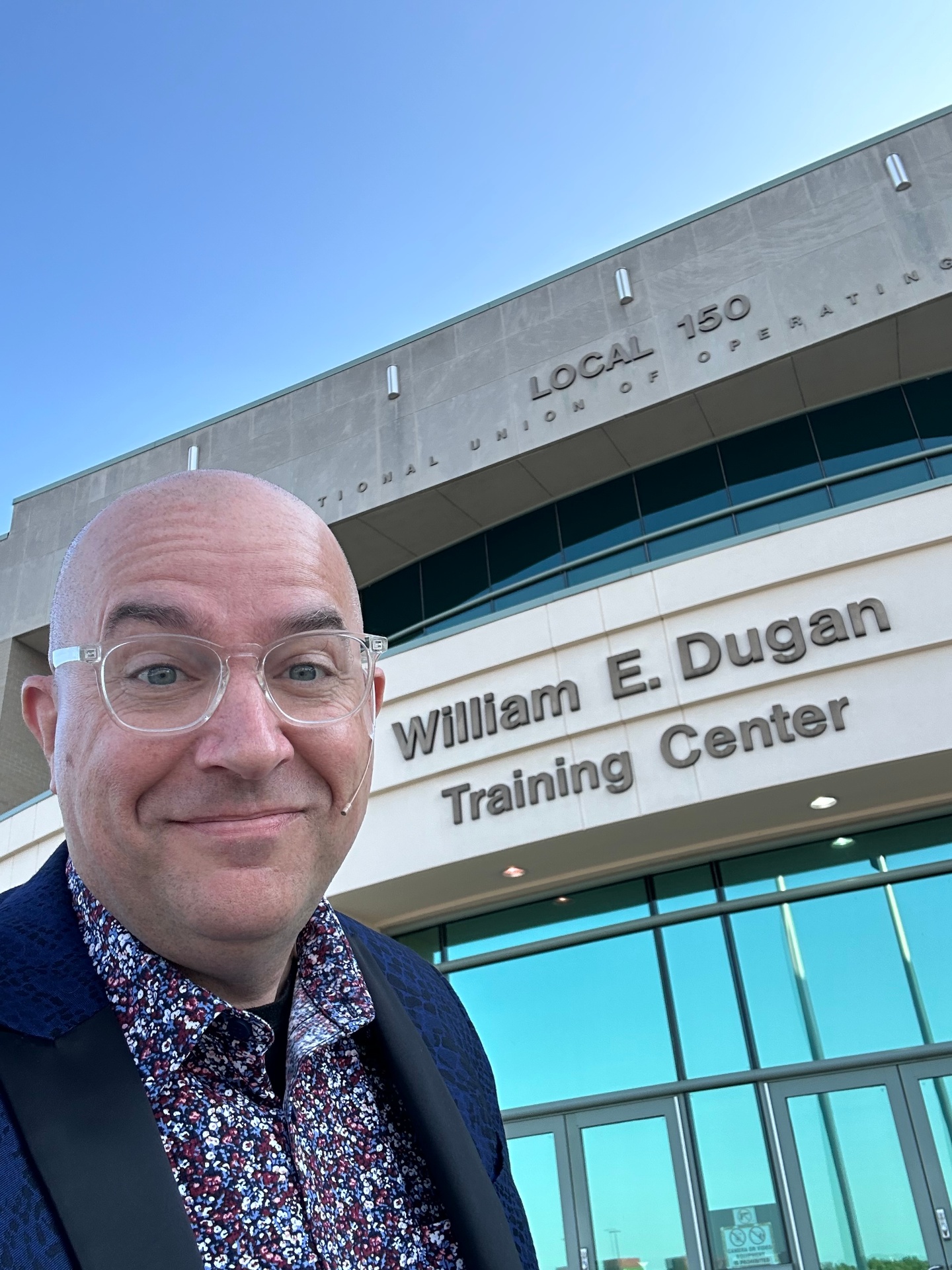 Tim smiling in front of the William E. Dugan Training Center before a keynote